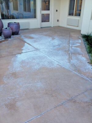 Efflorescence is a discoloration caused by crystalline deposits of salts on concrete surfaces. Try to wash or scrub it off as soon as it appears.  